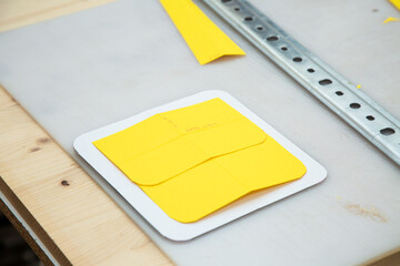 There is a cutting board that features a piece of yellow felt on it