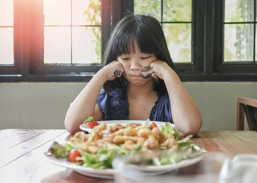 Asian kid, school girl child, picky eater with Anorexia, Bulimia Nervosa, eating problem, avoidant restrictive food intake disorder (ARFID), losing appetite with disliked healthy food meal
