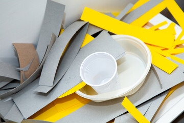 A stack comprised of various sheets of paper along with a plastic cup