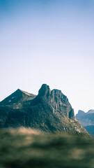 Romsdalshorn stands prominently amidst a majestic cluster of surrounding mountain peaks in the...