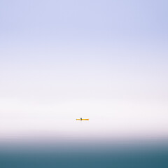 Kayaker paddling through misty Norwegian fjord surrounded by cliffs calm reflective water creates...
