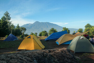 beautiful landscape of a mountain sunrise with a tent at a campground in the morning