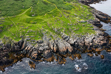Aerial View of Clogherhead Cliffs With People Relaxing Beside Rugged Greywacke And Mudstone Rocks On An Overcast Day