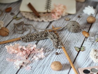 Knitting process, needles, cup of tea and different objects on the table beautiful photo	
