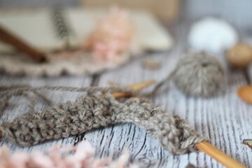 Knitting process, needles, cup of tea and different objects on the table beautiful photo	
