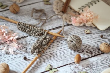 Knitting process, needles, cup of tea and different objects on the table beautiful photo	
