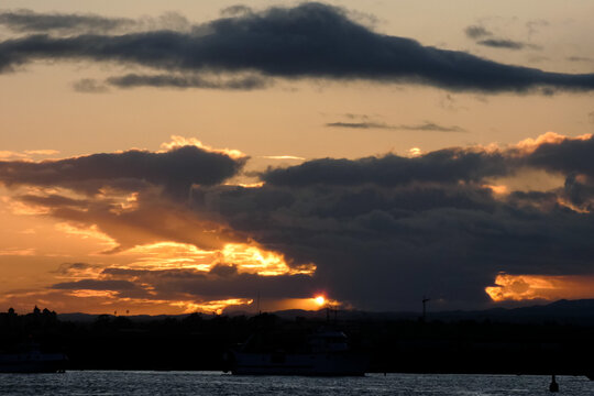 Golden sunset painting the clouds over dark hills