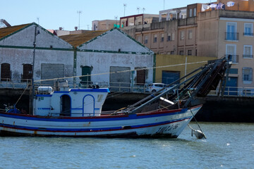 Obraz premium White motorboat floating on water near ria formosa natural park, portugal