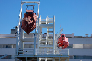 Davits holding lifeboats during a maritime safety exercise
