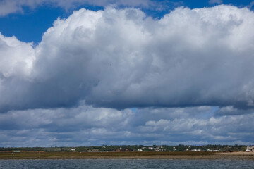 Bright white clouds drifting across deep blue sky