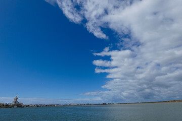 Bright white clouds drifting across deep blue sky