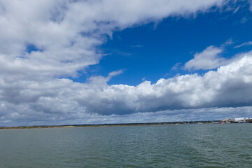 Bright white clouds drifting across deep blue sky