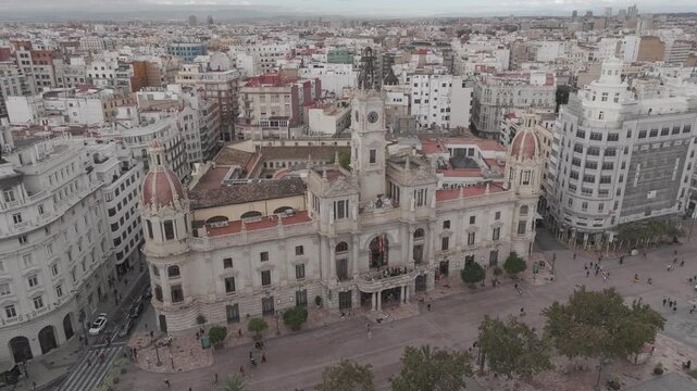 Descenso a&eacute;reo con dron sobre la fachada del Ayuntamiento de Valencia con vista contrapicada de la ciudad