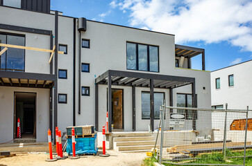 Modern townhouse under construction in a suburban neighborhood of Australia. An active construction site of contemporary residential development. Concept of real estate and housing.
