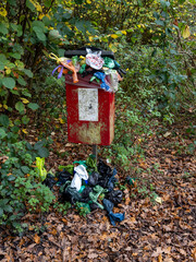 an overflowing dog poo collection bin