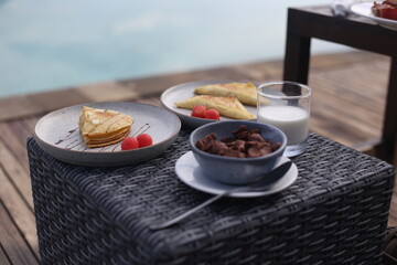Granola, Pancakes, and Toast with Milk on Wooden Table