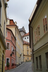 Charming cobblestone street in a historic neighborhood featuring colorful buildings and a castle in the background