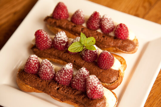 Chocolate eclairs topped with raspberries, French cafe, France