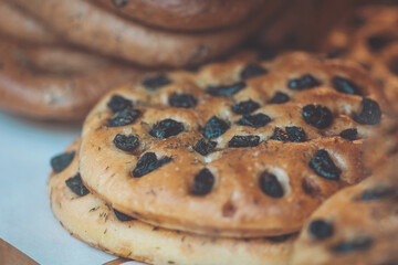 Freshly baked bread with olives displayed on a wooden table in a cozy bakery setting during the morning hours in a pleasant neighborhood