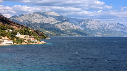 Fototapeta premium beautiful coastal landscape scenery with mountain Biokovo in background, Mimice, Dalmatia, Croatia, Adriatic sea at Mediterranean 