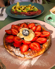 Fruit pancakes and avocado salmon toast served at outdoor brunch