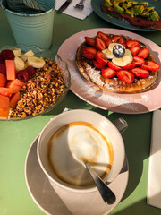 Brunch with coffee, fruit bowl and pancakes served outdoors