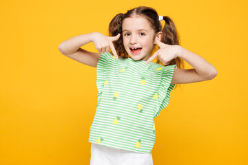 Little smiling cheery fun cute kid child girl 8-9 years old wears green t-shirt point index finger...