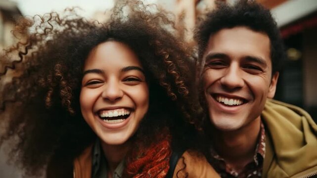 Two friends share laughter in a lively urban setting. They express happiness while enjoying each other's company on a cool daytime outing
