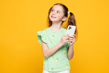 Little smiling fun cute kid child girl 8-9 years old wears green t-shirt hold use mobile cell phone...
