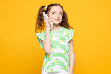 Little happy smiling cheery fun cute kid child girl 8-9 years old wears green t-shirt talk speak on...