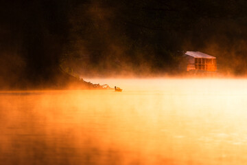 Ducks gliding on calm waters of Nymphensee Brieselang during golden hour warm sunlight casting soft...