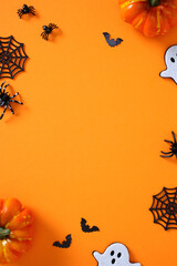 Happy Halloween vertical banner design. Flat lay pumpkins, spiders, ghosts, bats, and webs on...