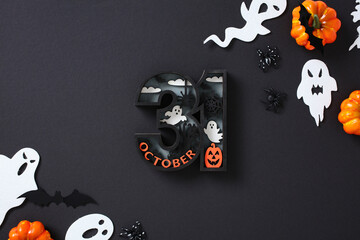 Halloween composition with 31 October text surrounded by ghosts, pumpkins, bats, spiders, and...