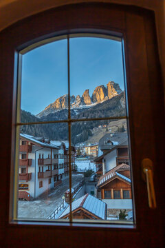 Window view of snow covered Campitello di Fassa and Grohmannspitze Punta Grohmann, Val di Fassa, Trentino, Italy