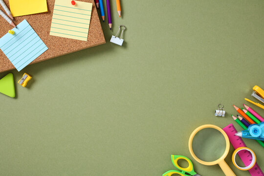 Top view colorful school supplies on green background with corkboard and sticky notes. Ideal for back-to-school, education, or creative workspace themes.