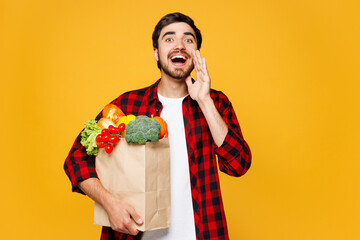 Young man wear casual clothes hold craft paper bag for takeaway mock up with food products scream...