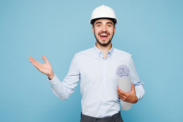 Young amazed architect engineer designer employee man wear white clothes shirt hardhat hold...