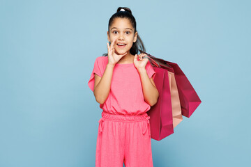 Little kid girl wear pink clothes hold paper package bags after shopping scream sharing hot news...