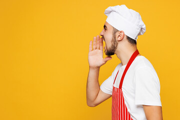 Young sad mad shocked housekeeper chef cook baker man wearing red apron toque hat holding hand near...