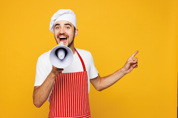 Young housewife housekeeper chef cook baker man wear red apron toque hat hold megaphone scream...