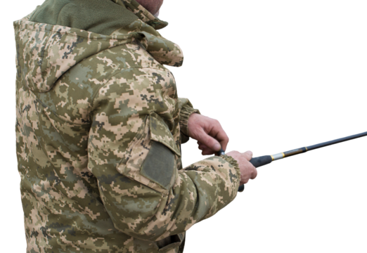 Fishing in the reeds for spinning on quiet water. A man in camouflage clothes in cool weather is fishing on the river bank. - Powered by Adobe