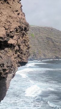 Waves crashing on the beach under the cliff.