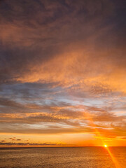 Farbenprächtiger Sonnenuntergang über dem Meer von Mauritius mit Wolken und sanften Wellen