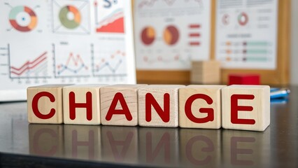 The word change in wooden blocks symbolizing business transformation and growth with data charts in the background