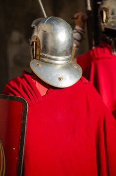 A Roman soldier with a shield, seen from behind at a historical reenactment.