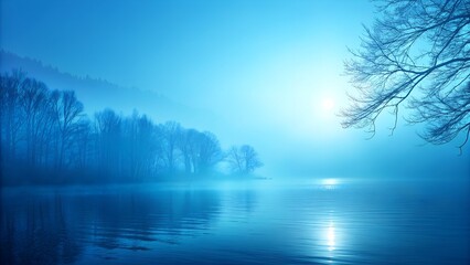Fototapeta premium Misty lake at dawn with silhouetted trees in blue hue