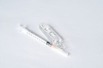 Medical syringe and ampule on white surface representing sterile healthcare equipment and...