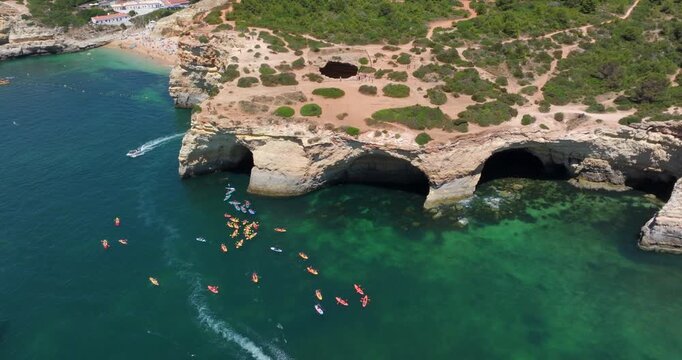 Aerial view of kayaks and boats at the famous Benagil Caves during summer in the Algarve coast, southern Portugal.