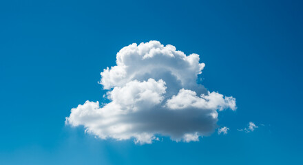 A fluffy white cumulus cloud floats serenely against a vibrant, clear, and expansive azure blue sky during a sunny day.