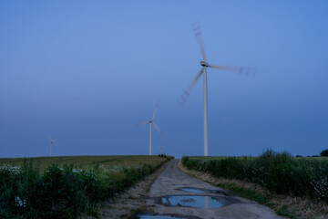 Windmills in a field - blurred blades symbolize movement towards the future. Green energy is...